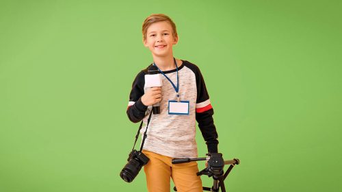 Little journalist with microphone and camera on color background