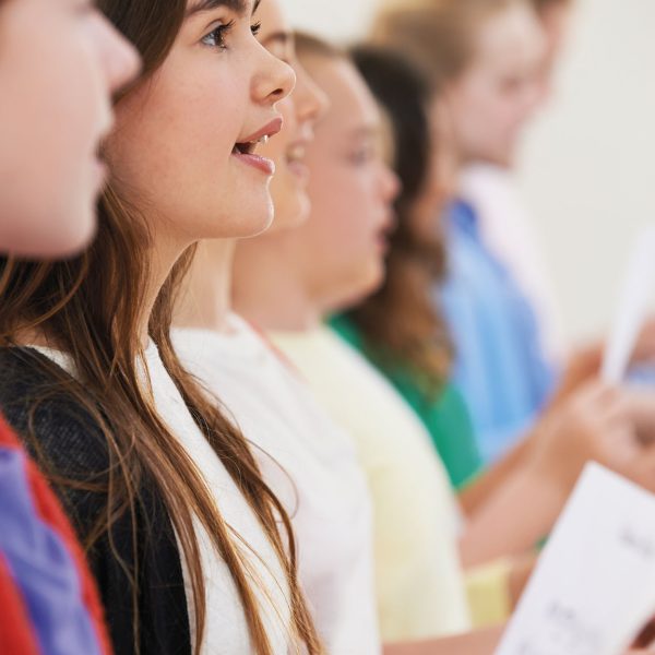 Group Of School Children Singing In Choir Together
